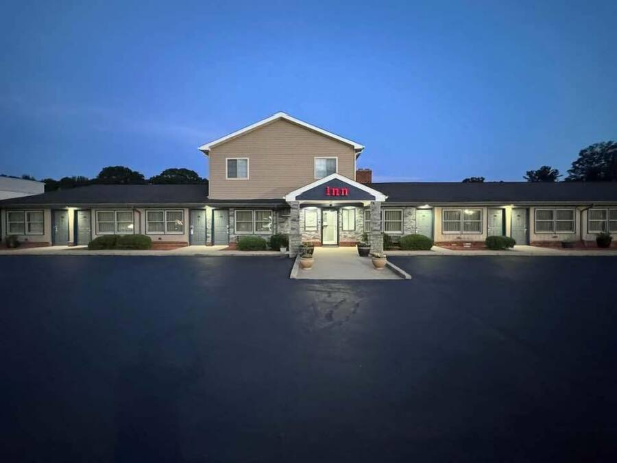 A two-story motel with a central entrance and a parking lot.