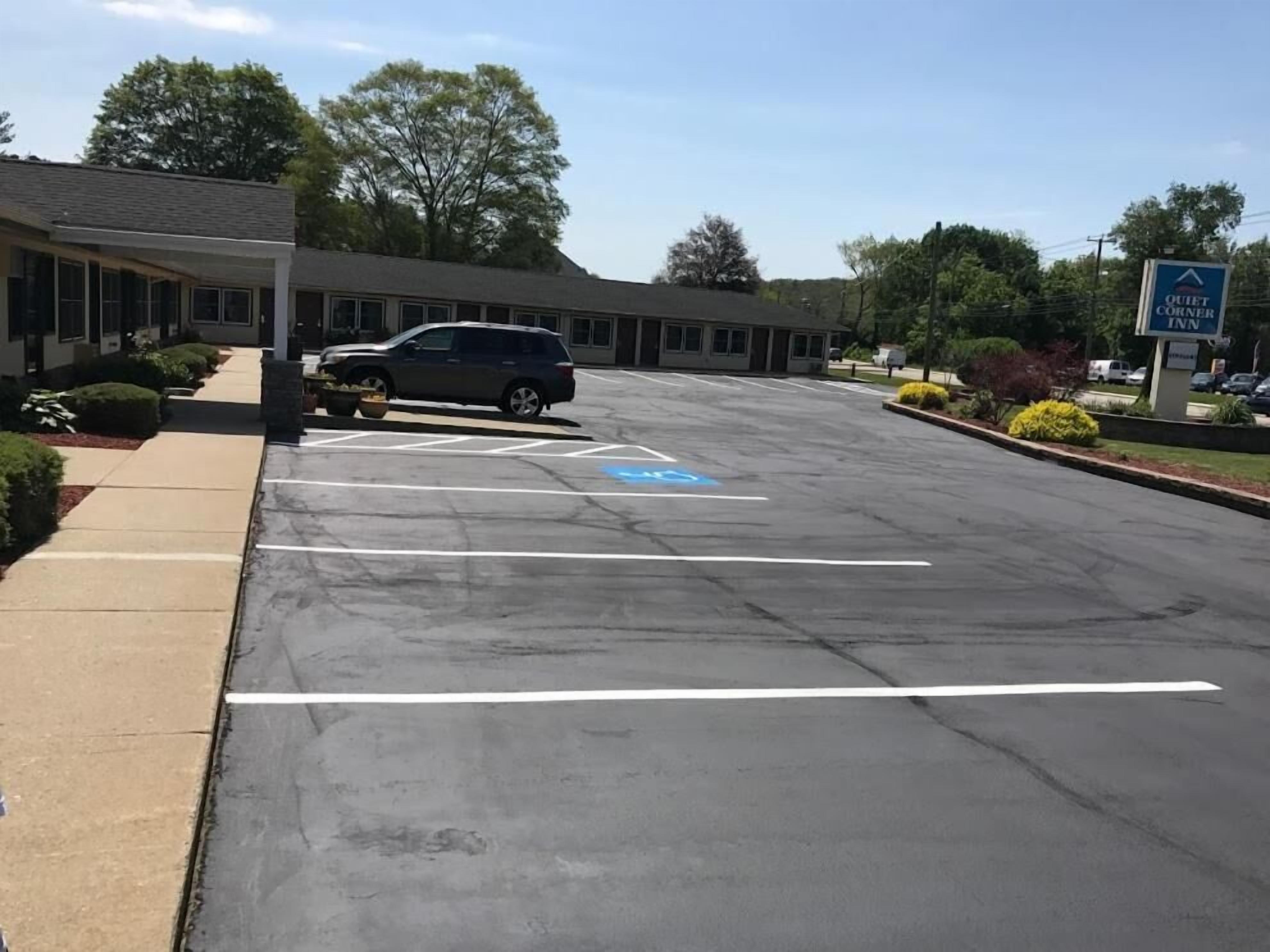 Un estacionamiento con un edificio al fondo identificado como "Quiet Corner Inn".