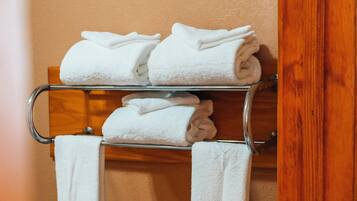 A metal towel rack with white and beige towels folded neatly.