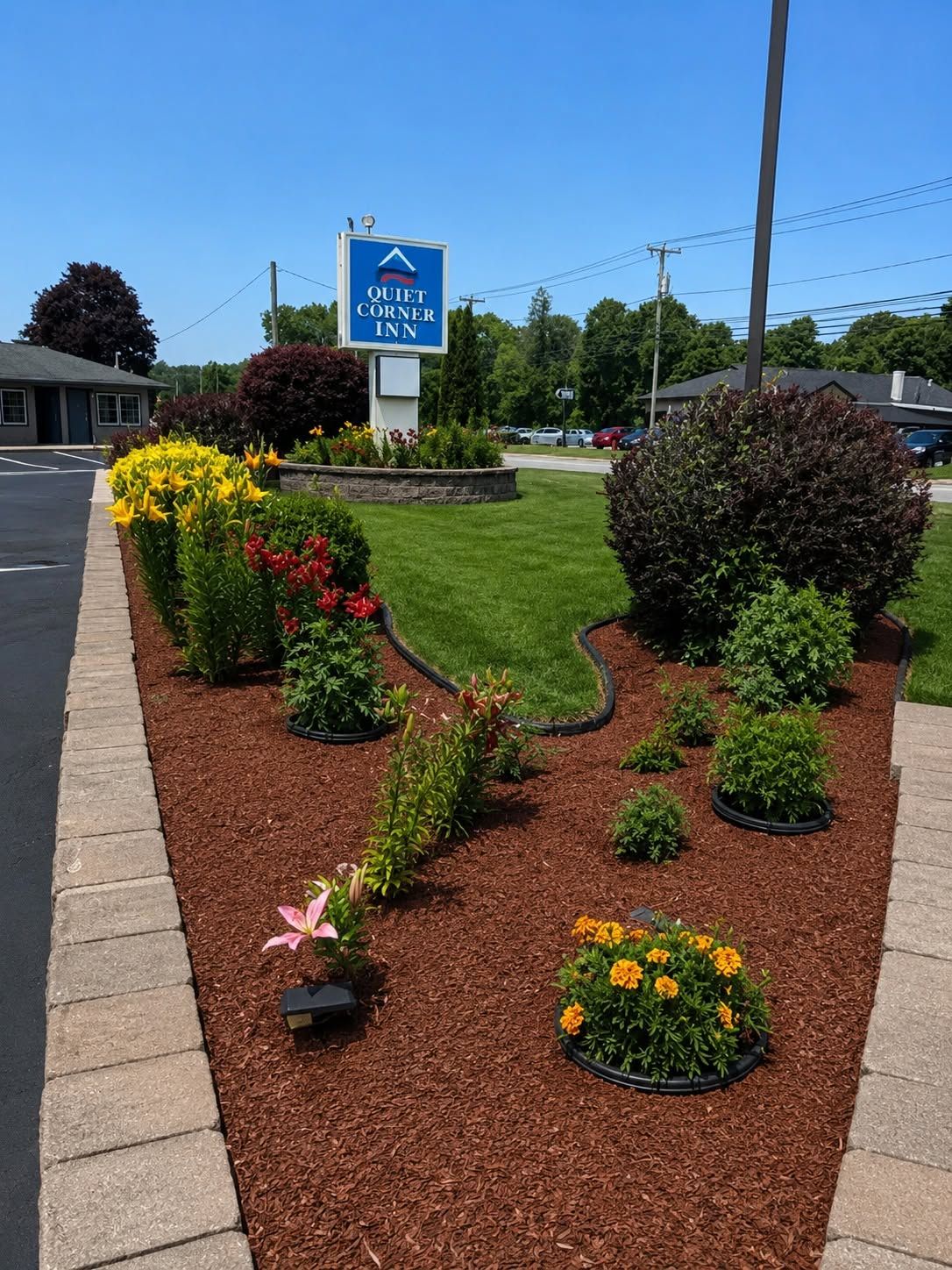 A QUIET CORNER INN sign with a landscaped garden featuring various plants and flowers.
