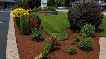 A QUIET CORNER INN sign with a landscaped garden featuring various plants and flowers.