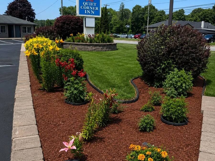 A QUIET CORNER INN sign with a landscaped garden featuring various plants and flowers.
