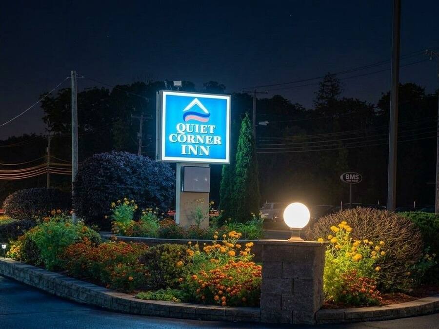 Schild für das Quiet Corner Inn bei klarem Nachthimmel, beleuchtet.