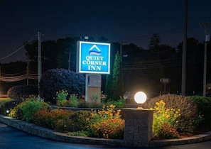 Señal del Quiet Corner Inn con un cielo nocturno despejado y letrero iluminado.