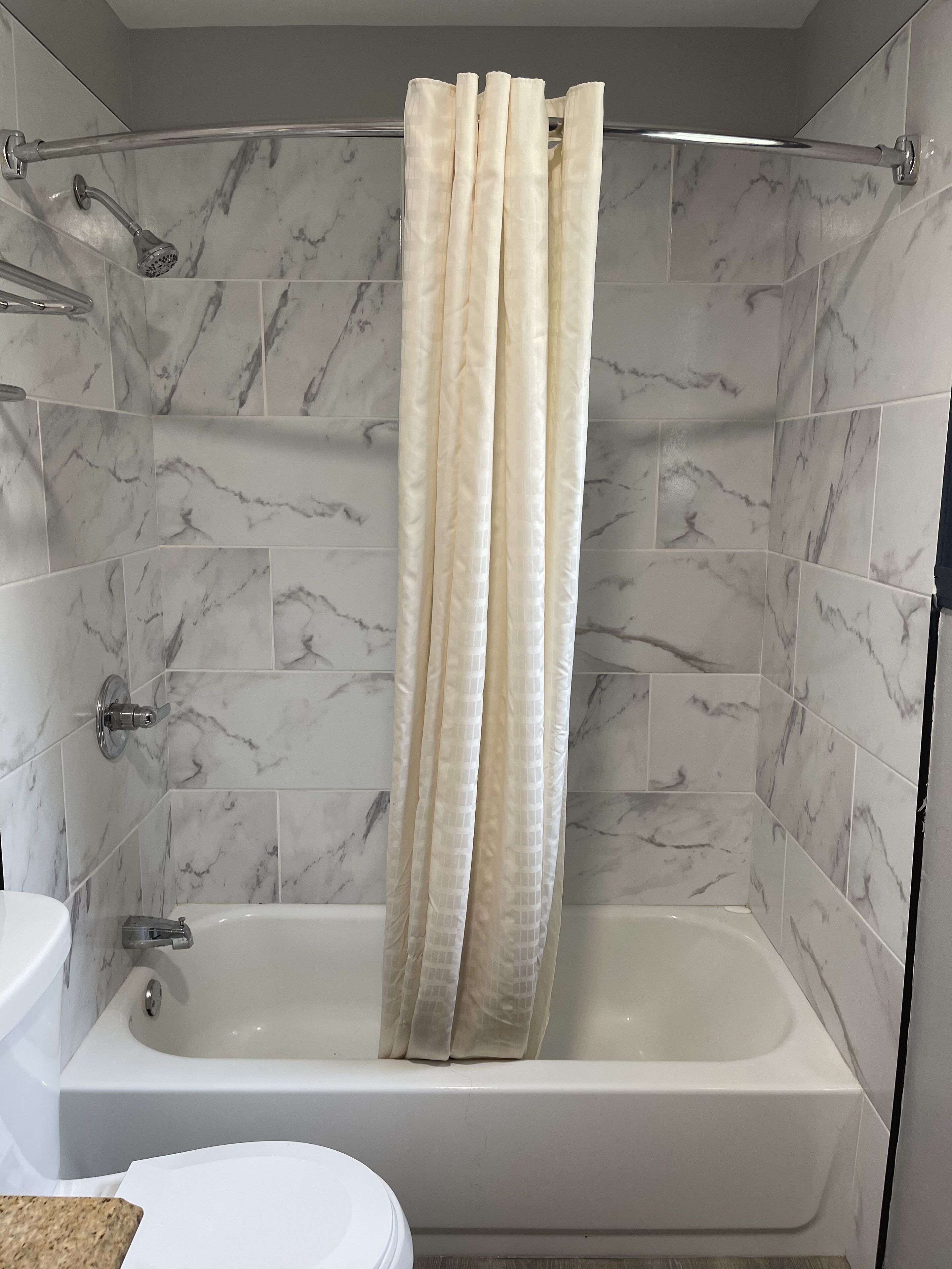 A bathroom with a bathtub, a shower, and a toilet.