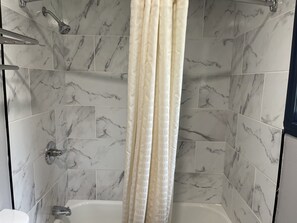 Habitación estándar, 1 cama Queen size | Baño | Tina con regadera, amenidades de baño gratuitas, secadora de cabello 