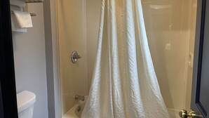A shower with a glass door, a towel rack with folded towels, and a toilet visible in the corner. - Golden Hill Inn Danbury (Danbury)