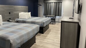 A hotel room with two beds, a desk, a chair, a telephone, and a television. - Golden Hill Inn Danbury (Danbury)