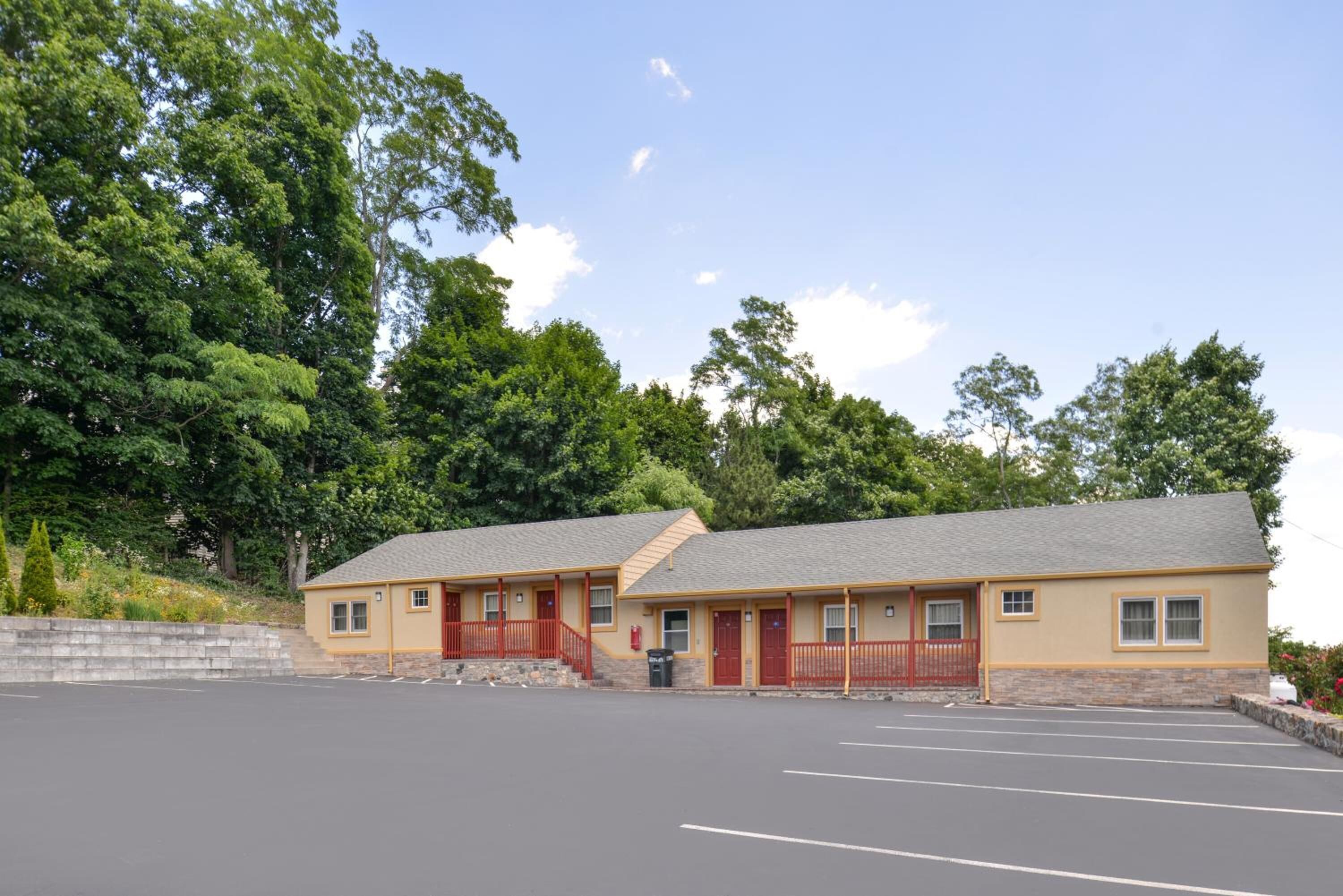 A motel with two single-story buildings, each with a red door and a small porch.