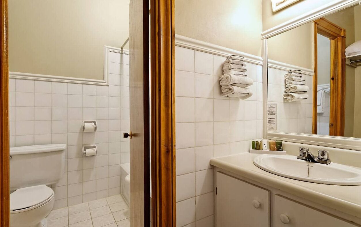 A bathroom with a toilet, sink, and towel rack.