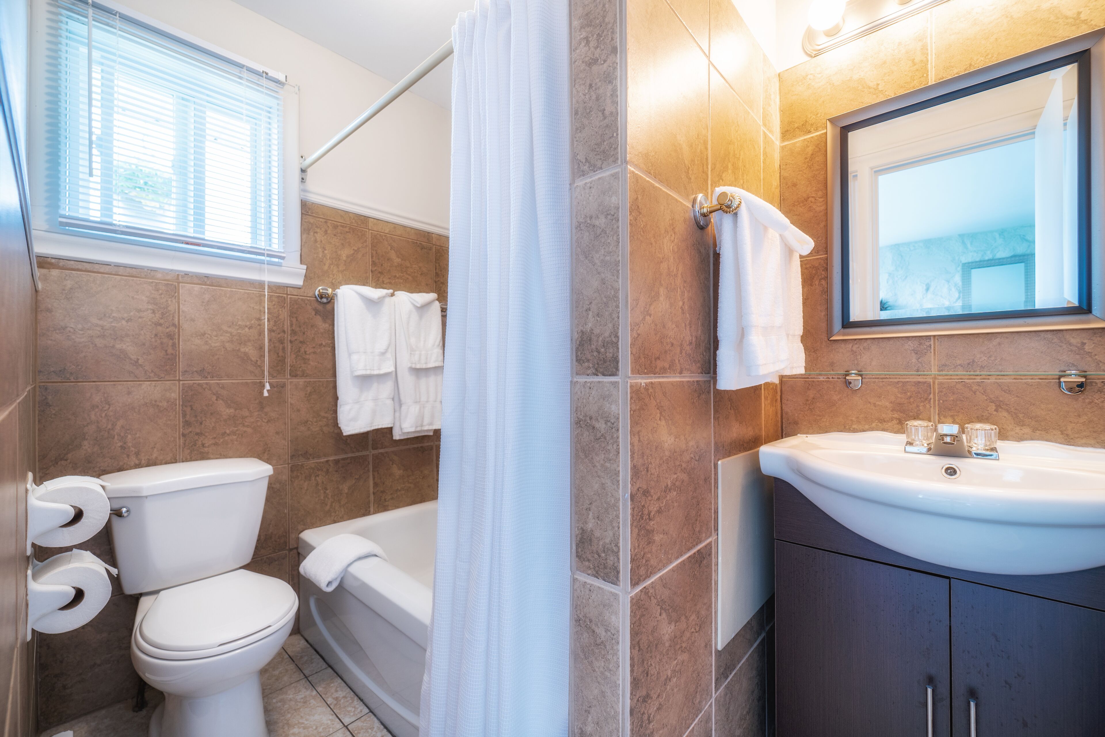 Une salle de bain comprenant des toilettes, une baignoire et un lavabo.