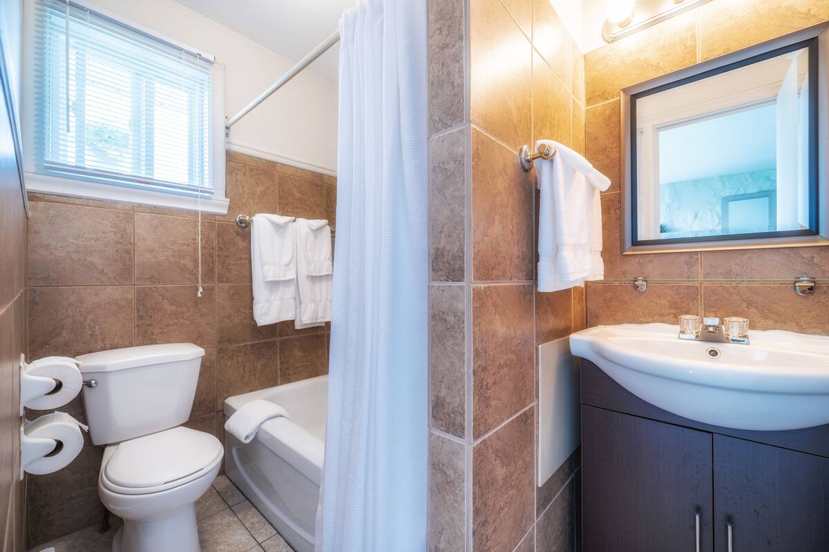 Een badkamer met toilet, bad en wastafel.
