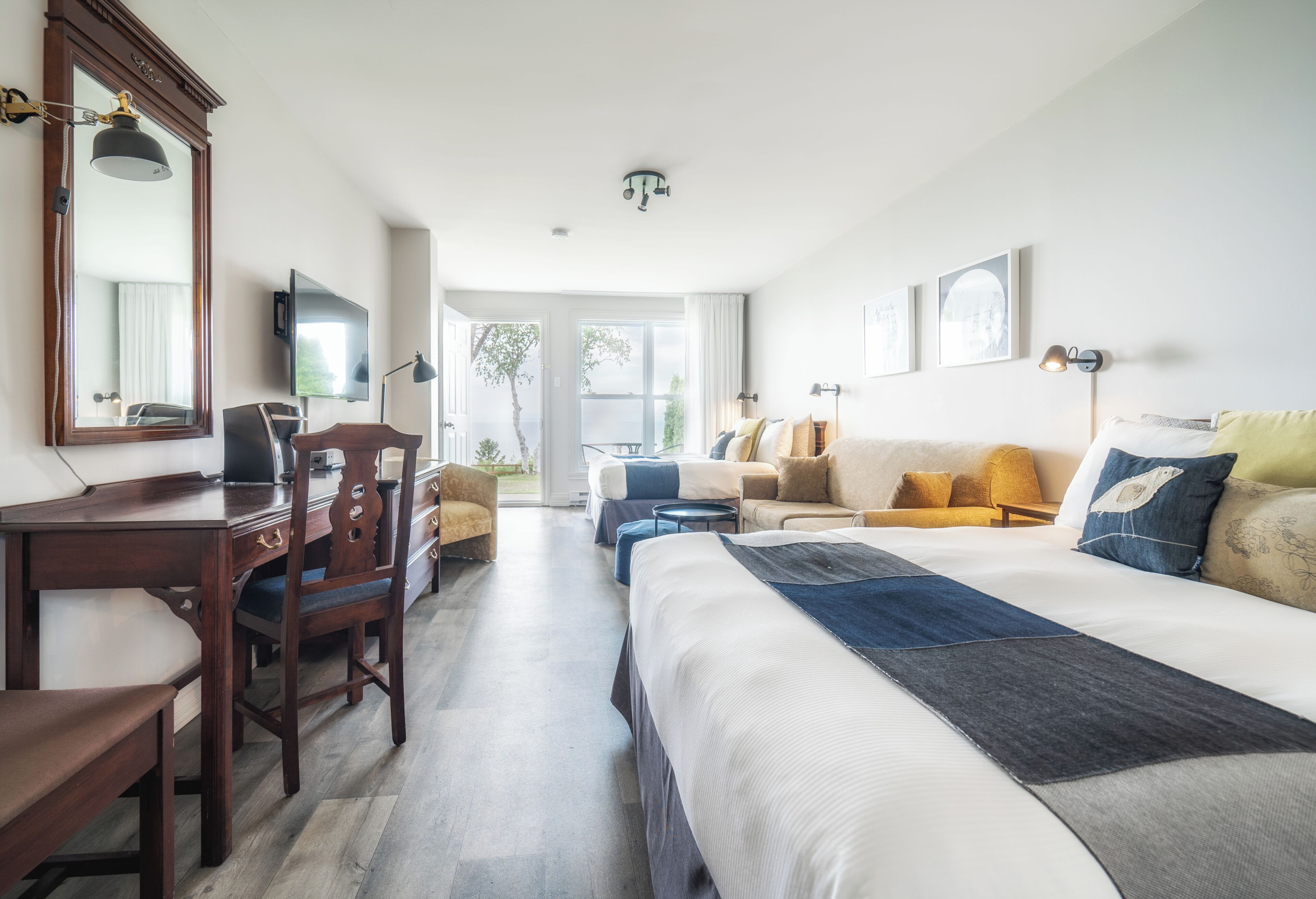 Une chambre d’hôtel équipée d’un lit, d’un bureau, d’une chaise, d’un canapé et d’une télévision.