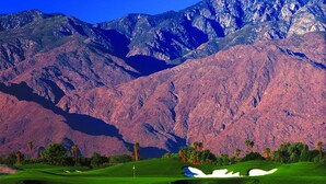 A golf course with a clear reflection in a body of water, surrounded by mountains. - Raintree's Cimarron Golf Resort (Cathedral City)