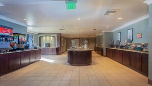 Un hall d’hôtel avec un îlot central, un réfrigérateur à boissons Coca-Cola et un réfrigérateur à boissons Pepsi.