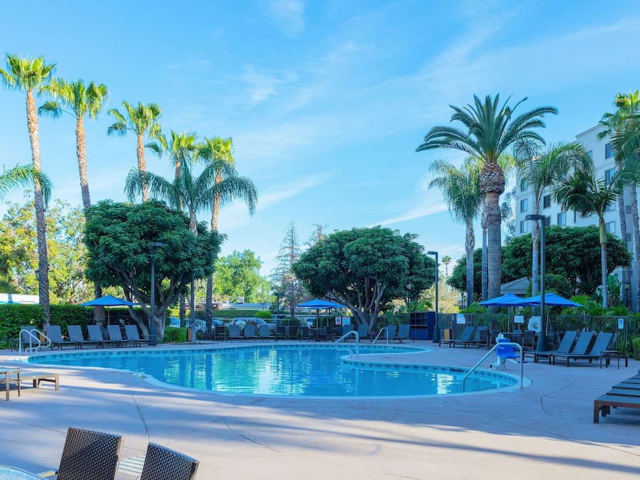 Een buitenzwembad, ligstoelen bij het zwembad