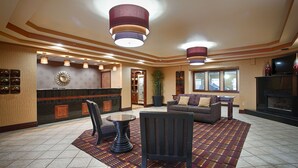 A lobby with a reception desk, seating area, and a fireplace. - Best Western Plus Midwest Inn & Suites (Salina)