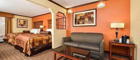 Ein Hotelzimmer mit einem Bett, einem Schlafsofa, einem Couchtisch und einem Nachttisch mit Lampe.