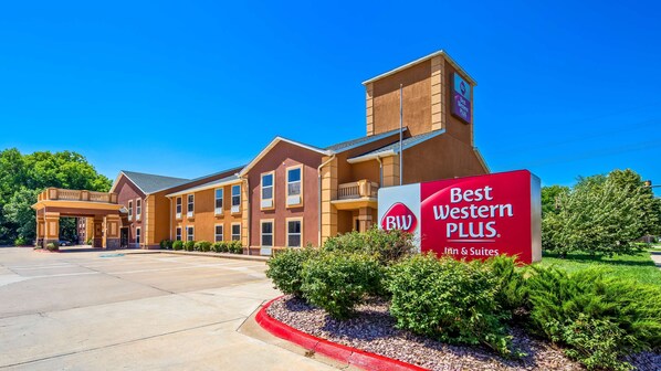 Un hotel Best Western Plus con un diseño moderno, que presenta una entrada destacada y un cielo azul claro.
