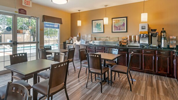 A restaurant with a bar area, tables, chairs, and a coffee machine.