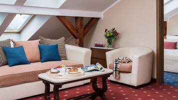 Une pièce confortable avec un canapé, un fauteuil et une table où sont disposés des éléments pour le petit-déjeuner.