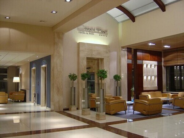 A hotel lobby with a reception desk, seating area, and a sign indicating 'Royal Post Hotel & Spa'. - Booking Hotel & Spa (Kraków)