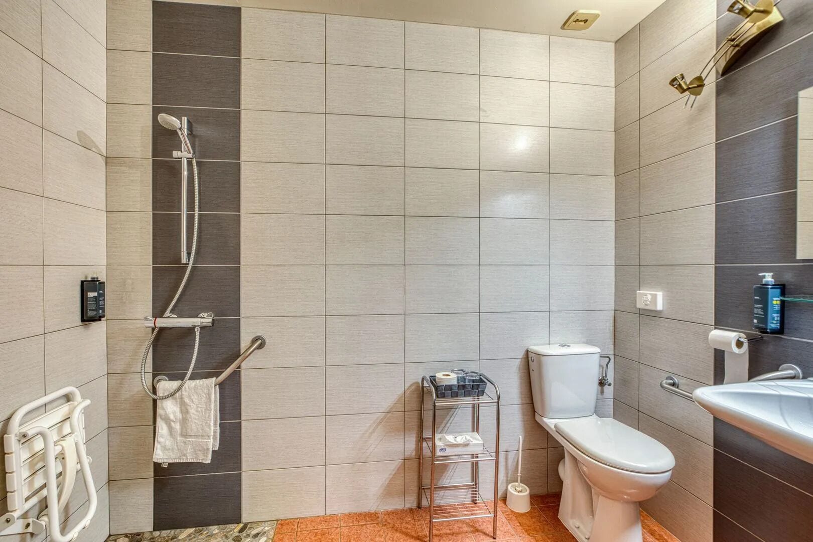 Un baño moderno con ducha, inodoro y lavamanos.