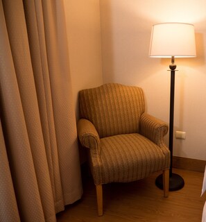 A corner room with a patterned armchair, a floor lamp, and a curtain. - Holiday Inn Express Guanajuato by IHG (Guanajuato)