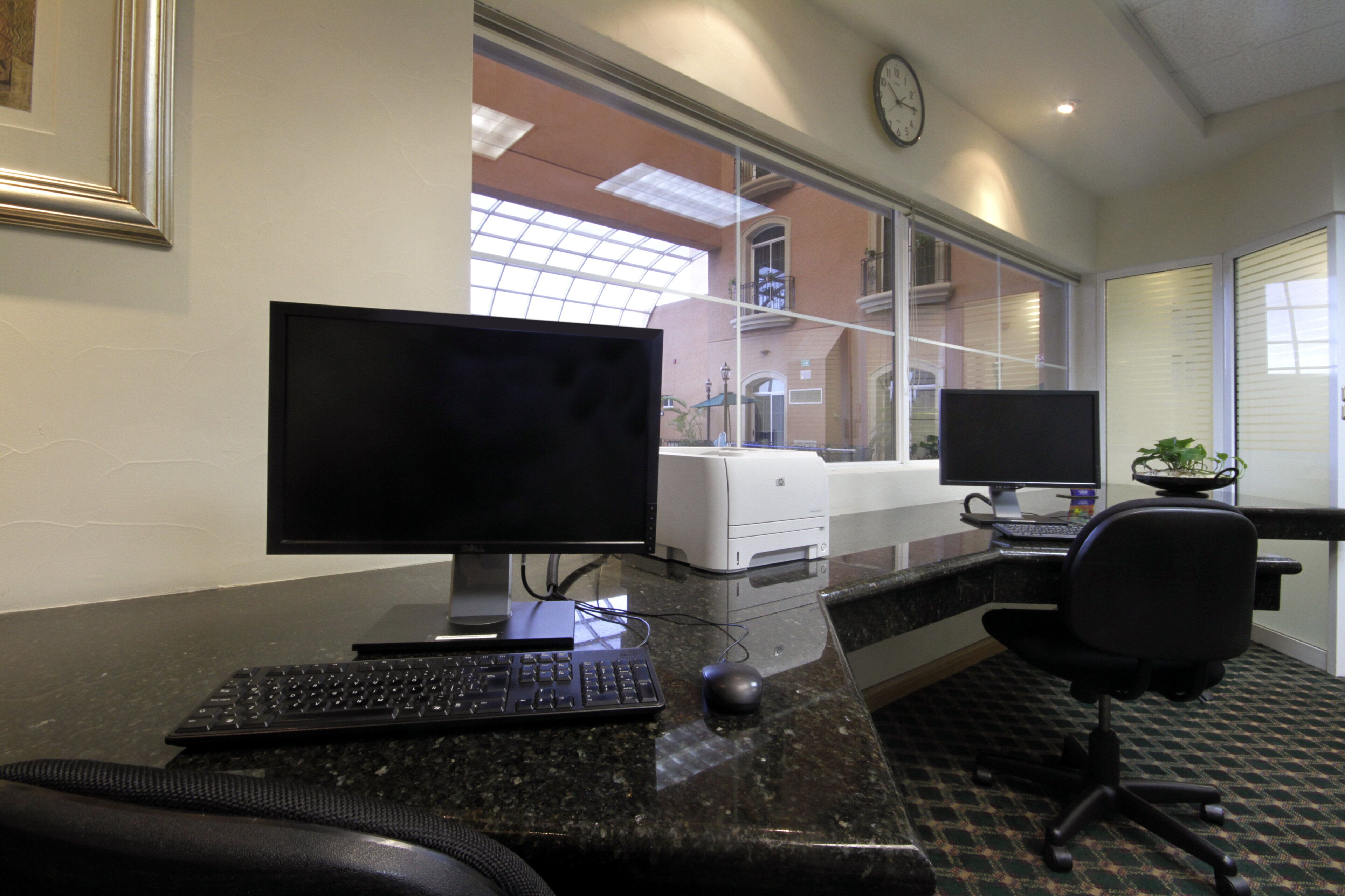 A modern office space with a desktop computer, a printer, and a chair.