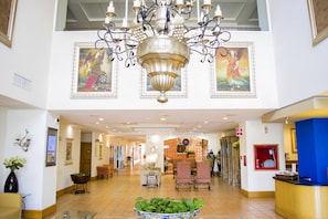 A hotel lobby with a chandelier, artwork, seating area, and reception desk. - Holiday Inn Express Guanajuato by IHG (Guanajuato)