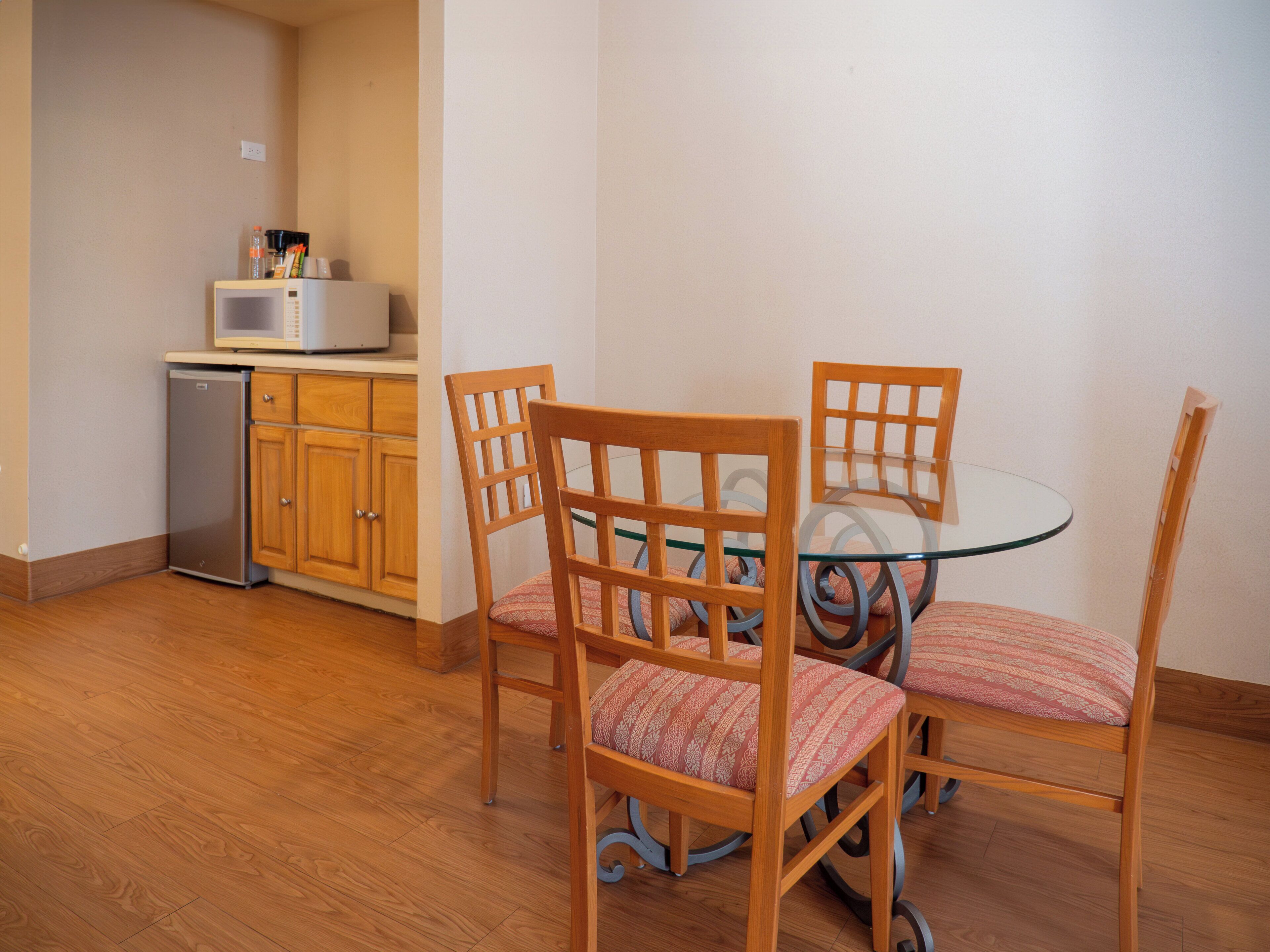 A compact kitchen with wooden cabinets and a built-in microwave.