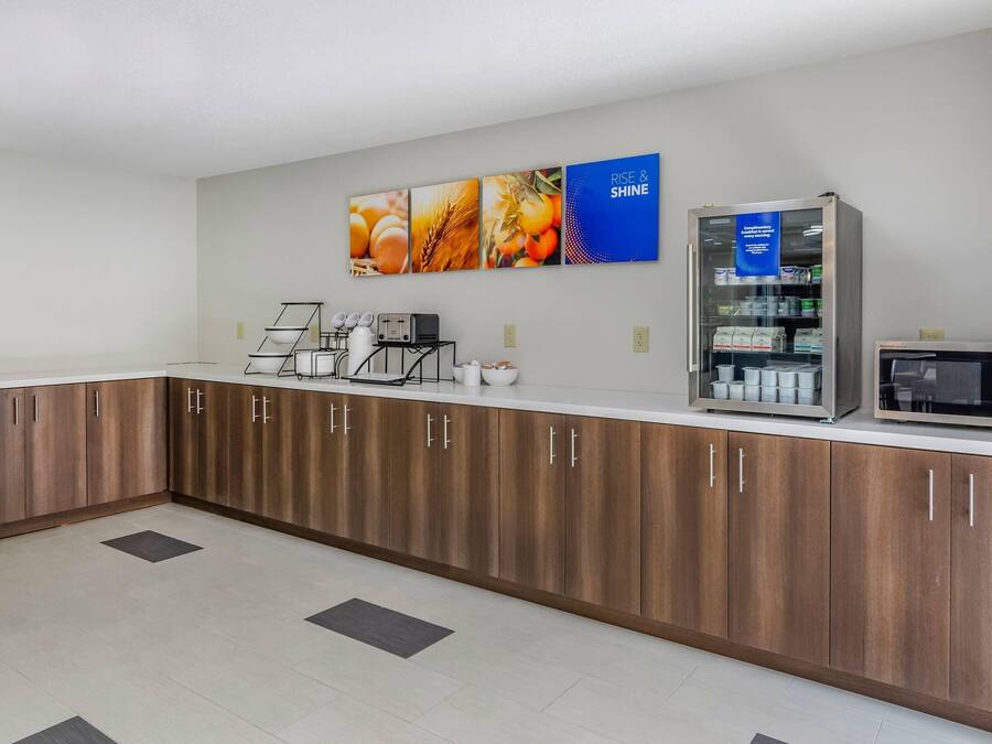 A kitchenette with a microwave, coffee maker, and a refrigerator.