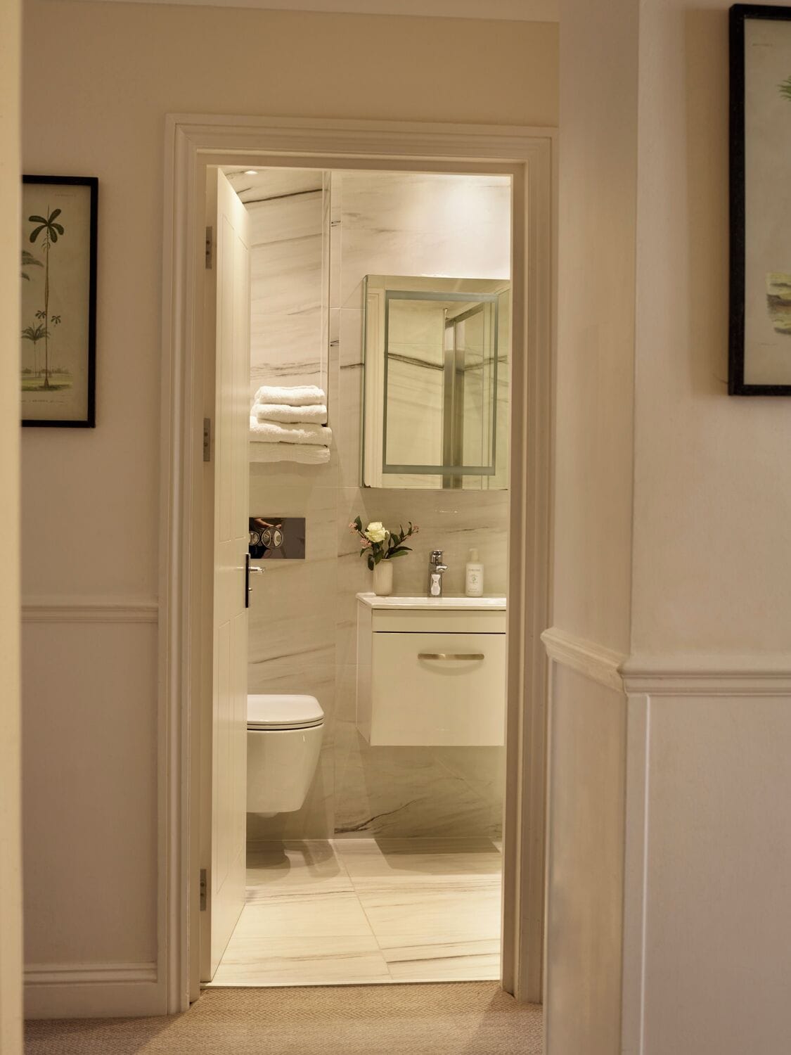 A bathroom with a toilet, sink, and mirror.