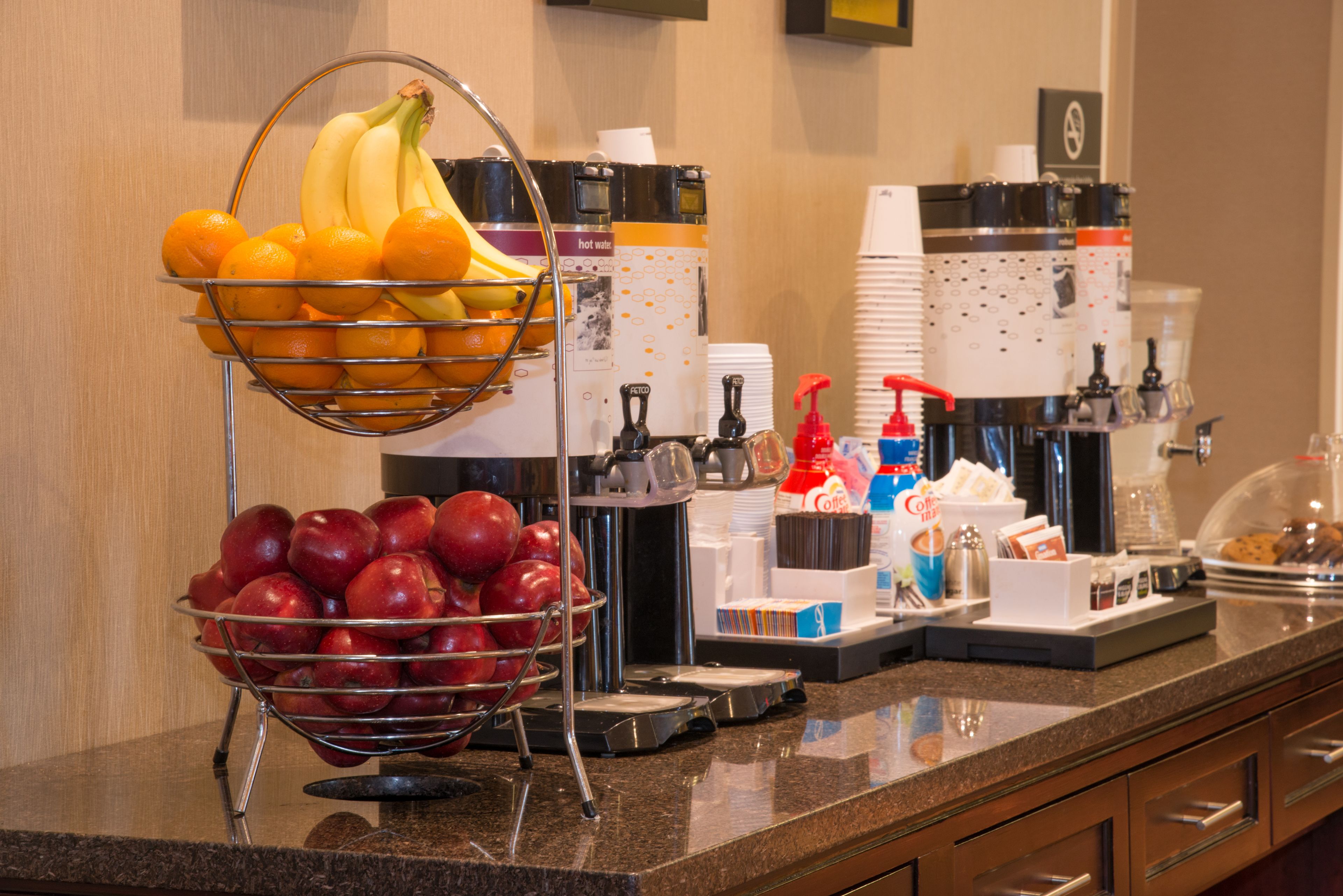Un bufé de desayuno con frutas, café y té.