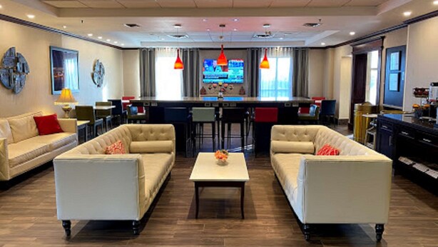 A spacious living area with two sofas, a coffee table, and a bar area with stools.