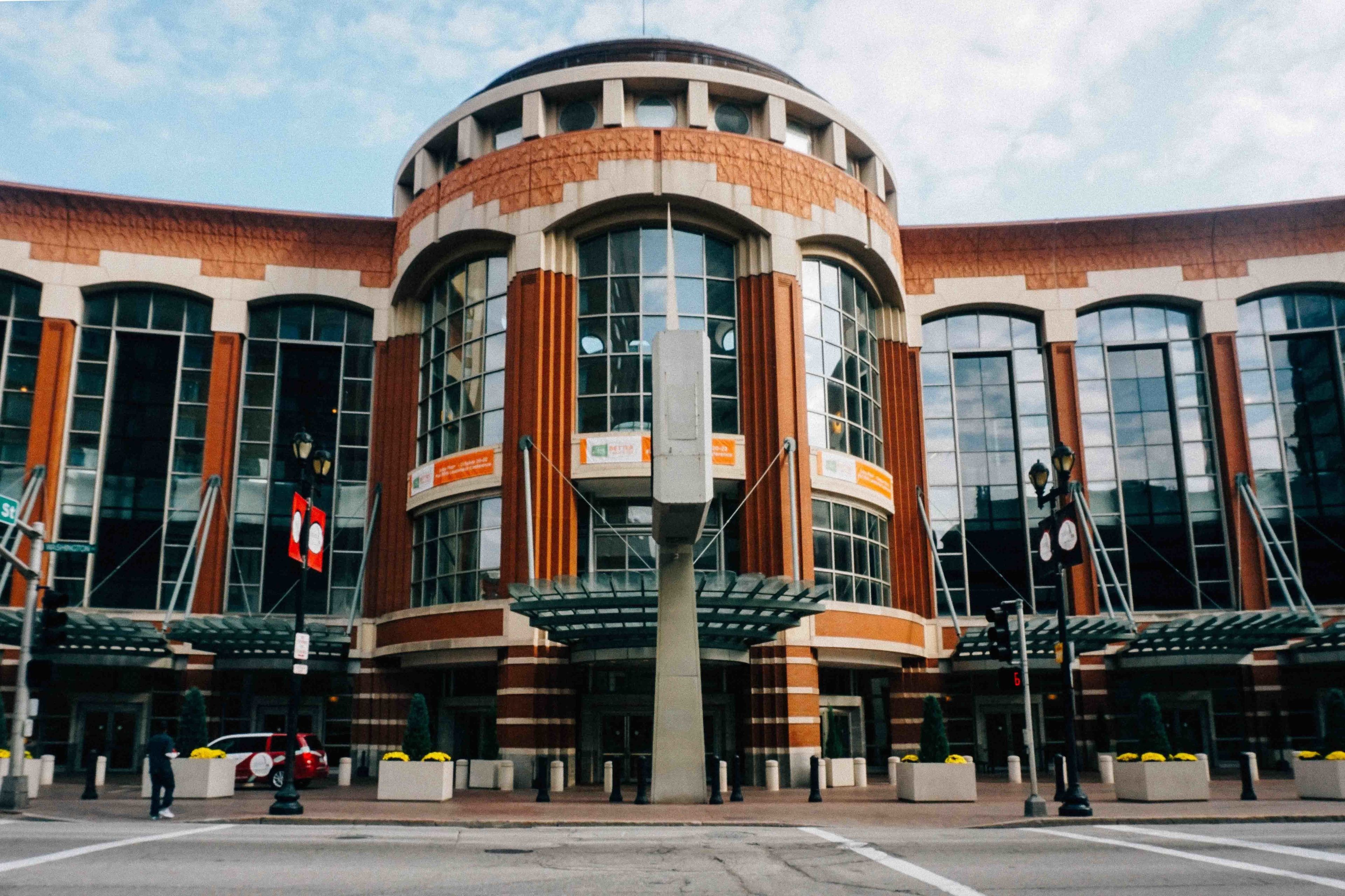 A modern building with a curved facade, large windows, and a central entrance with a glass canopy.