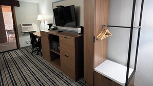 A hotel room with a bed, a desk with a computer, a TV, and a wardrobe. - AmericInn by Wyndham Cloquet (Cloquet)