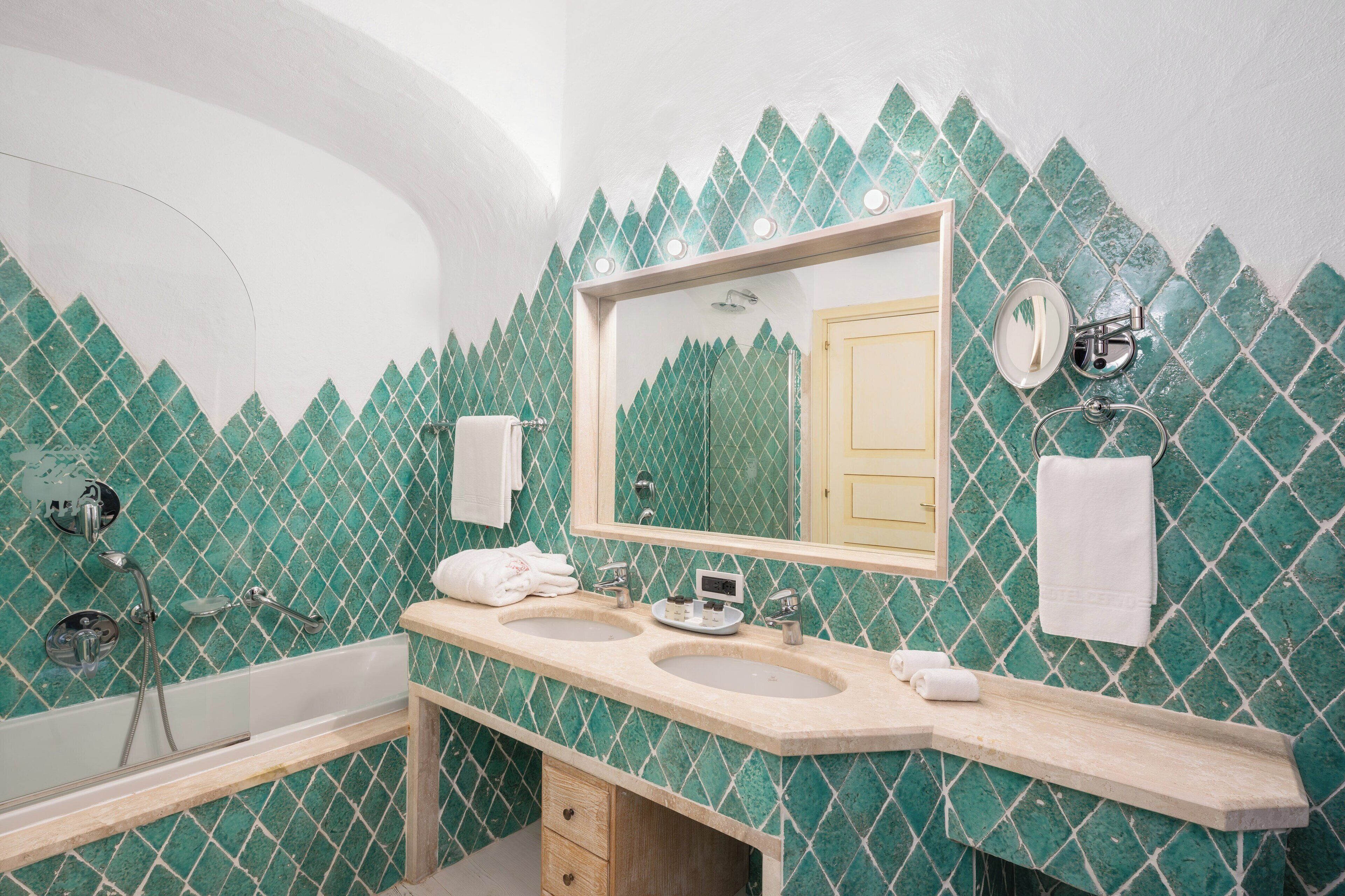 A bathroom with two sinks, a large mirror, and a shower.