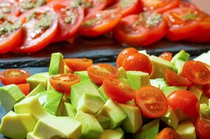 A tray of sliced tomatoes and avocado.