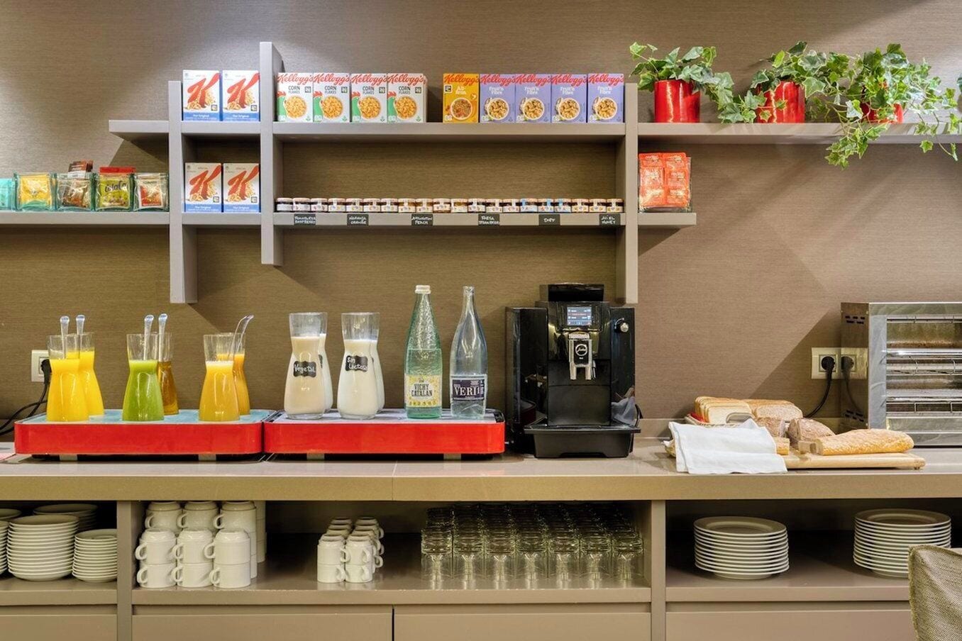 Un comptoir de petit-déjeuner avec des boîtes de céréales, des bouteilles de lait et une machine à café.