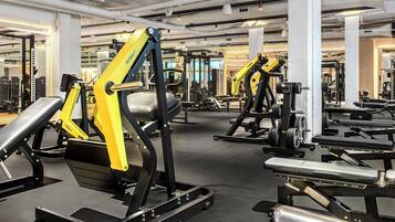 Un gimnasio con diversos equipos de ejercicio, incluyendo máquinas de pesas y pesas libres.