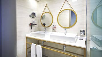 Een moderne badkamer met twee wasbakken, een spiegel en een handdoekhouder.