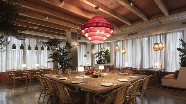 A spacious dining area with a large wooden table, wicker chairs, and pendant lighting. - Hesperia Sevilla (Seville)