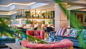 A modern hotel lobby with a bar area, seating arrangements, and decorative elements. - Hesperia Sevilla (Seville)