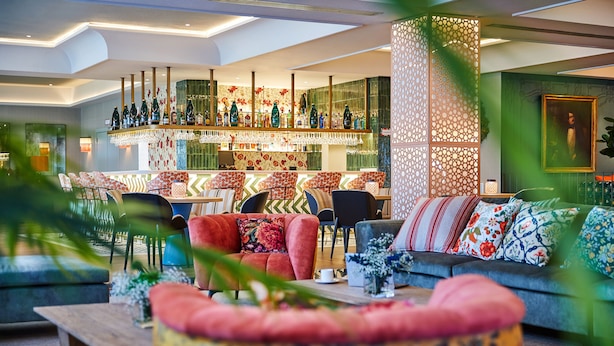 A modern hotel lobby with a bar area, seating arrangements, and decorative elements. - Hesperia Sevilla (Seville)