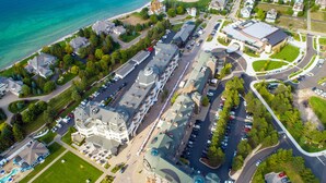 An aerial view of a hotel with multiple buildings, parking lots, and a beachfront. - Village Suites Bay Harbor (Petoskey)