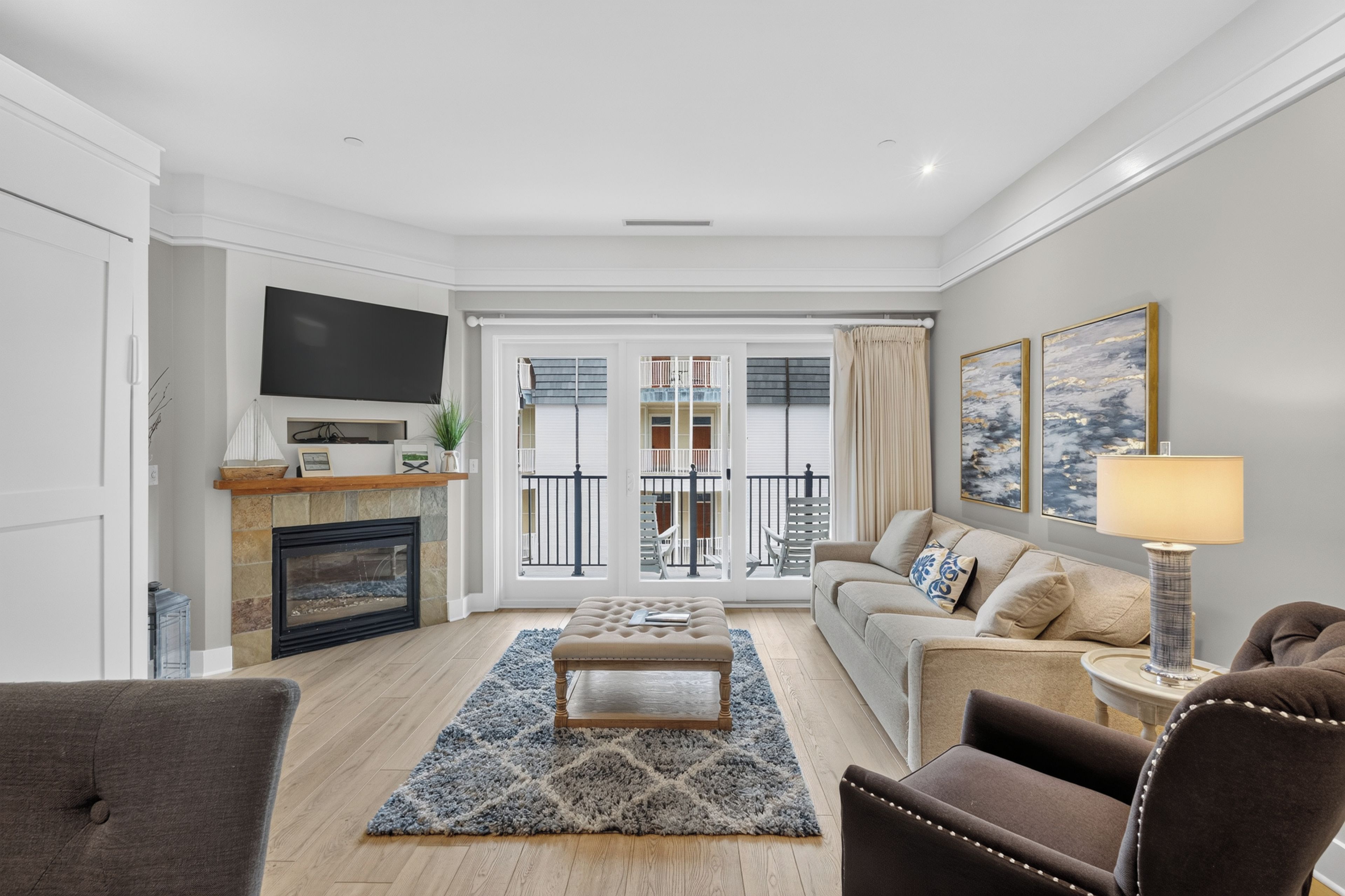 A modern living room with a fireplace, a flat-screen TV, a sofa, a coffee table, and a lamp.
