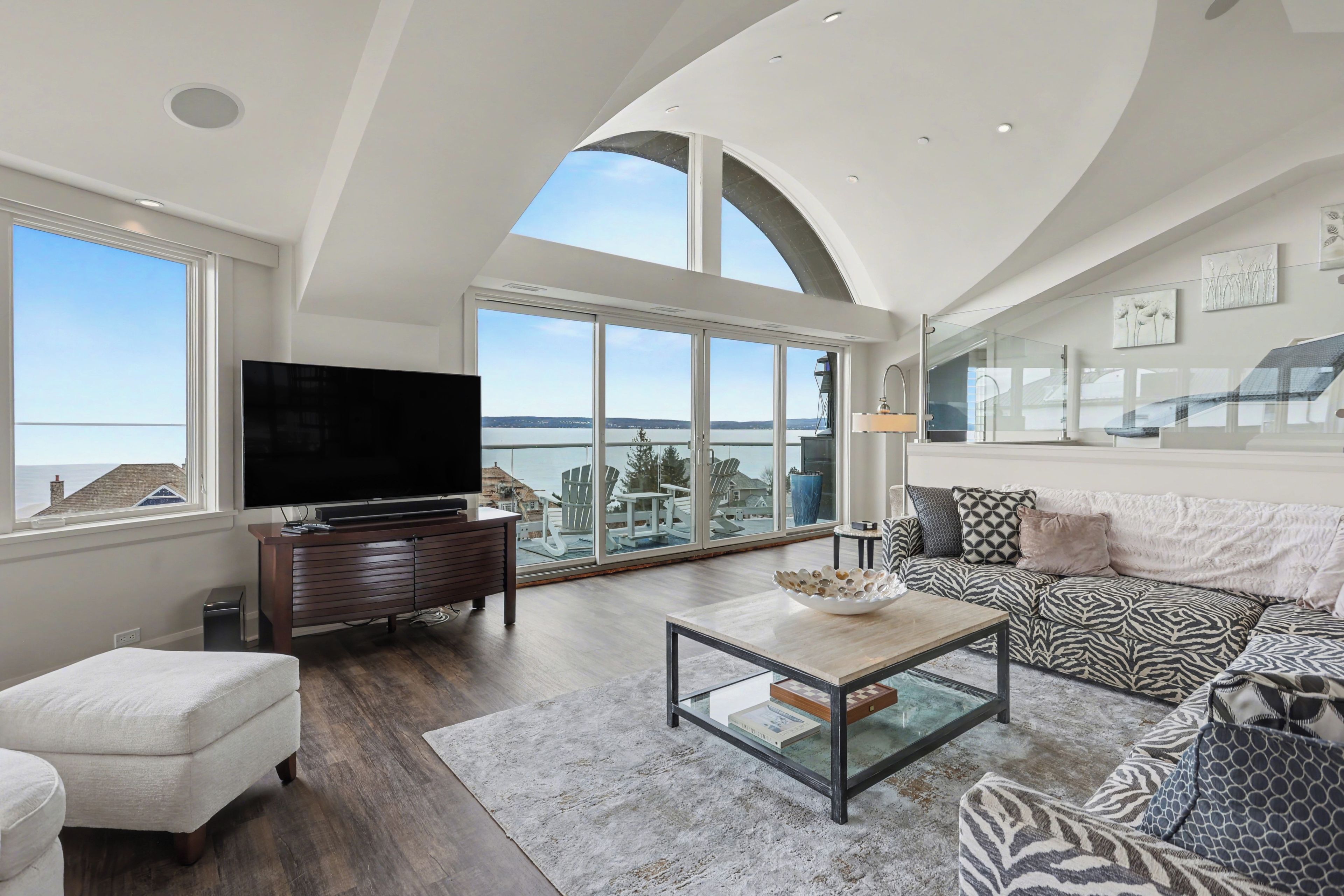 A spacious living room with a large flat-screen TV, a comfortable sofa, and a coffee table.