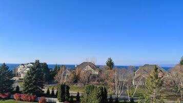 A residential area with houses, a parking lot, and a view of the sea.