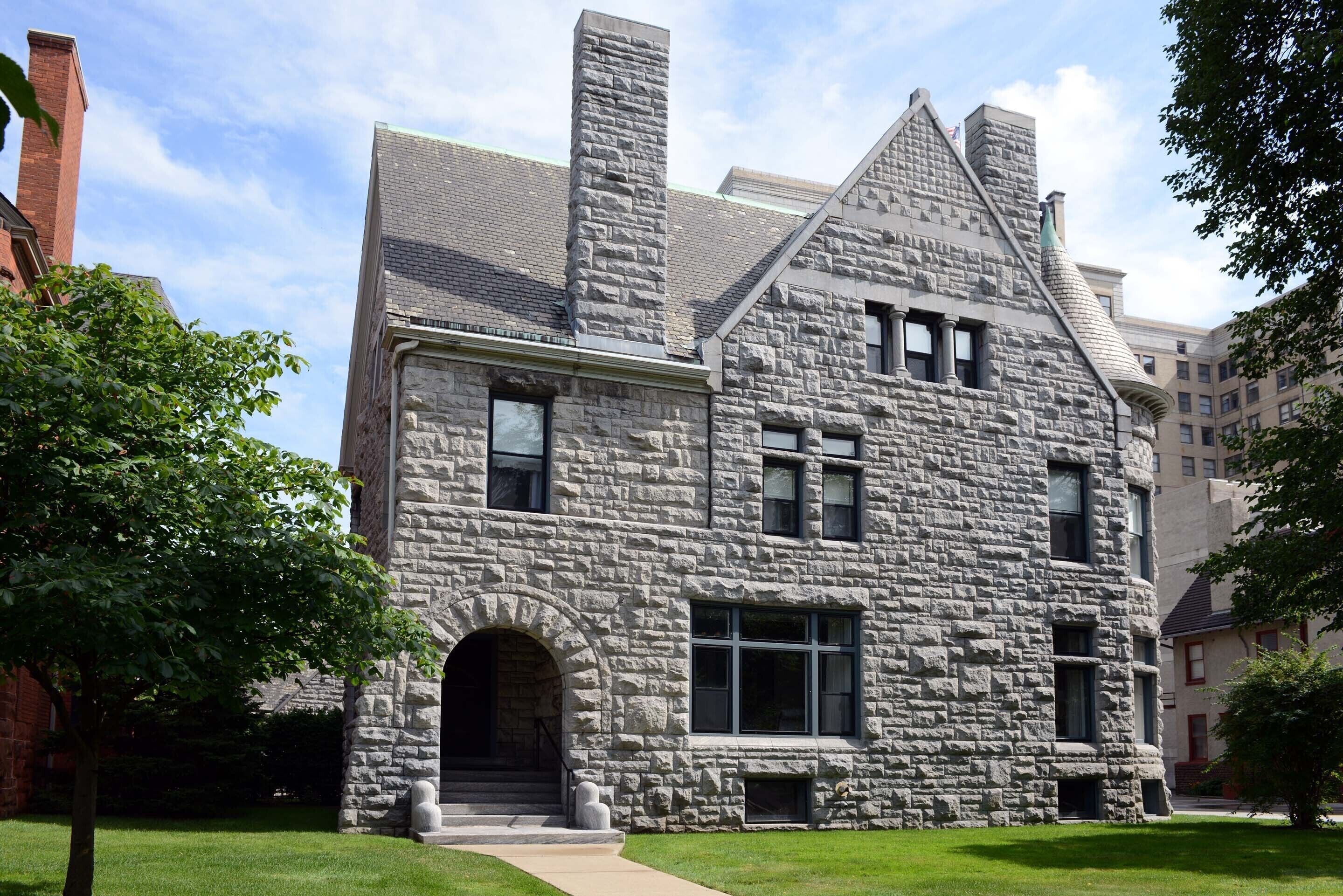 A stone building with a prominent arched entrance and multiple windows.